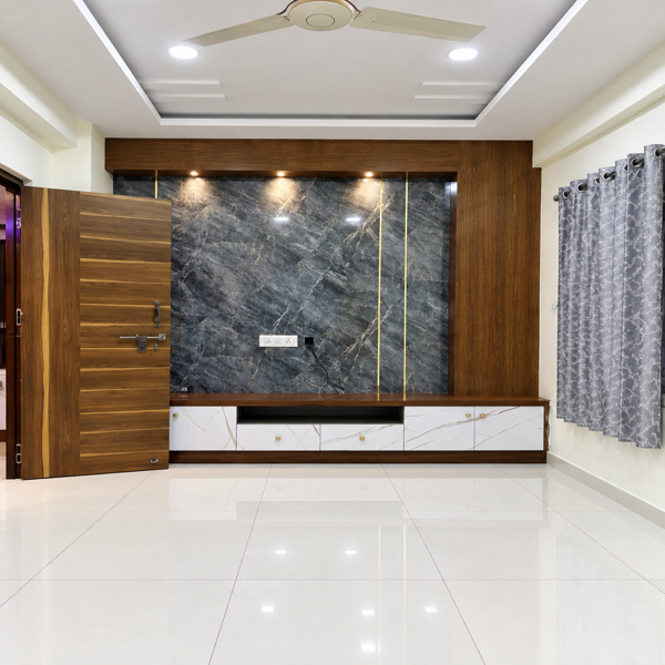 Modern TV unit, living room TV wall, black marble TV panel, dark marble wall, wooden TV console, contemporary living room, TV cabinet, media wall, entertainment unit, marble texture, black and gray marble, wooden wall panel, modern living room, Indian living room, modern Indian home, TV backdrop, feature wall, accent wall, floating console, low profile cabinet, white marble drawers, storage cabinet, built in storage, wall mounted TV unit, LED spotlights, warm lighting, recessed lighting, ceiling fan, false ceiling, polished floor, glossy tiles, curtain design, gray curtains, window treatment, spacious room, minimalist living room, luxury interior, elegant home, contemporary decor, residential interior, home interior design, interior architecture, modern furniture, custom TV unit, bespoke cabinetry, TV console design, media console, entertainment center, storage drawers, cabinet handles, wood and marble design, dark interior accents, neutral palette, gray interior, brown wood finish, sophisticated decor, clean lines, functional design, home renovation, living room makeover, interior inspiration, home decor ideas, modern home styling, Indian interior design, designer TV unit, premium TV wall, marble TV backdrop, modern cabinetry, custom furniture, built in furniture, display unit, TV wall lighting, architectural lighting, ambient lighting, ceiling design, residential design, apartment interior, family room, media room, home entertainment, stylish living room, contemporary styling, uncluttered room, premium interiors, modern architecture, elegant TV wall, luxury living space, functional storage, polished marble, wooden cabinetry, dark marble finish, white storage drawers, living room furniture, modern decor, home furnishing, interior photography, designer interiors, sophisticated home, clean interior, spacious living area.